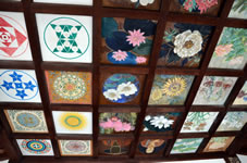 大師堂の天井に、草花や大師の肖像などが色鮮やかに描かれた天井画が見えます。