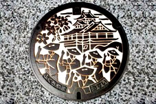福知山城と福知山音頭を踊っている絵柄が描かれた福知山市のマンホールです。