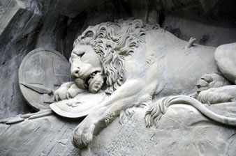 約2000万年前の砂岩に彫られた彫刻のライオンは、脇腹に槍が刺さり今にも息絶えてしまいそうな表情を浮かべて身を横たえています。